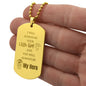 Gift for Dad Dog Tag Necklace in gold with engraved message and illustrations held in hand