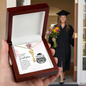 Graduation Cap Name Necklace in a wooden gift box with a smiling graduate holding flowers in the background