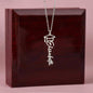 Graduation Cap Necklace with the name Elizabeth in silver hanging in front of a wooden box