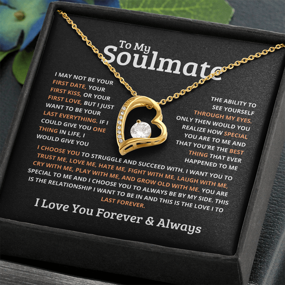 Gold heart-shaped necklace for gold with a central gemstone on a soulmate message card