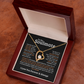 Gold heart-shaped necklace for gold with a sparkling stone in an open wooden gift box